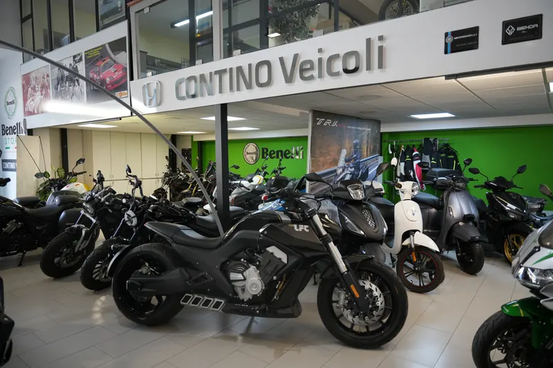 Interno del salone Contino Veicoli con l'insegna e le moto esposte